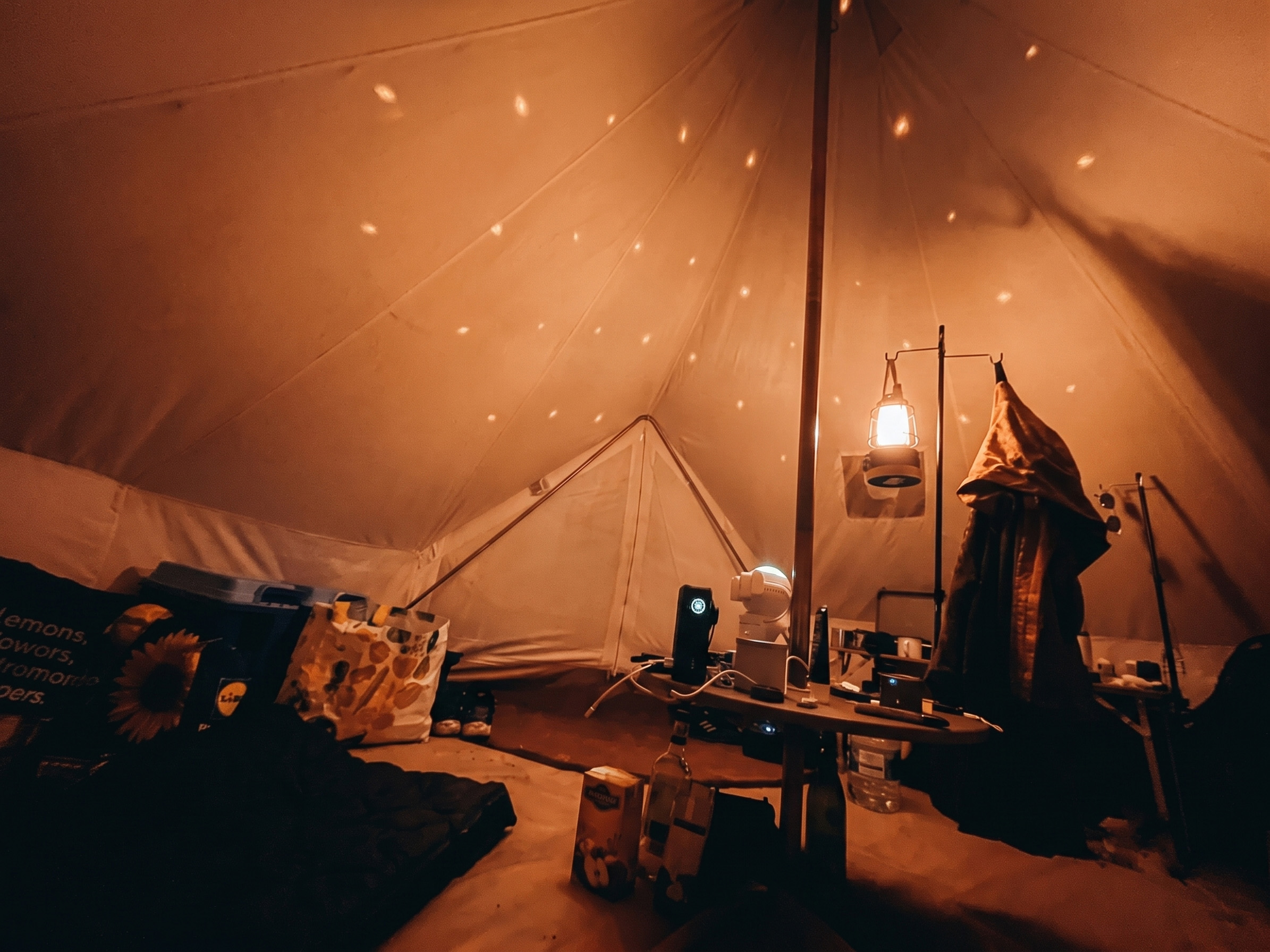 Inside cosy bell tent illuminated with laser light projector