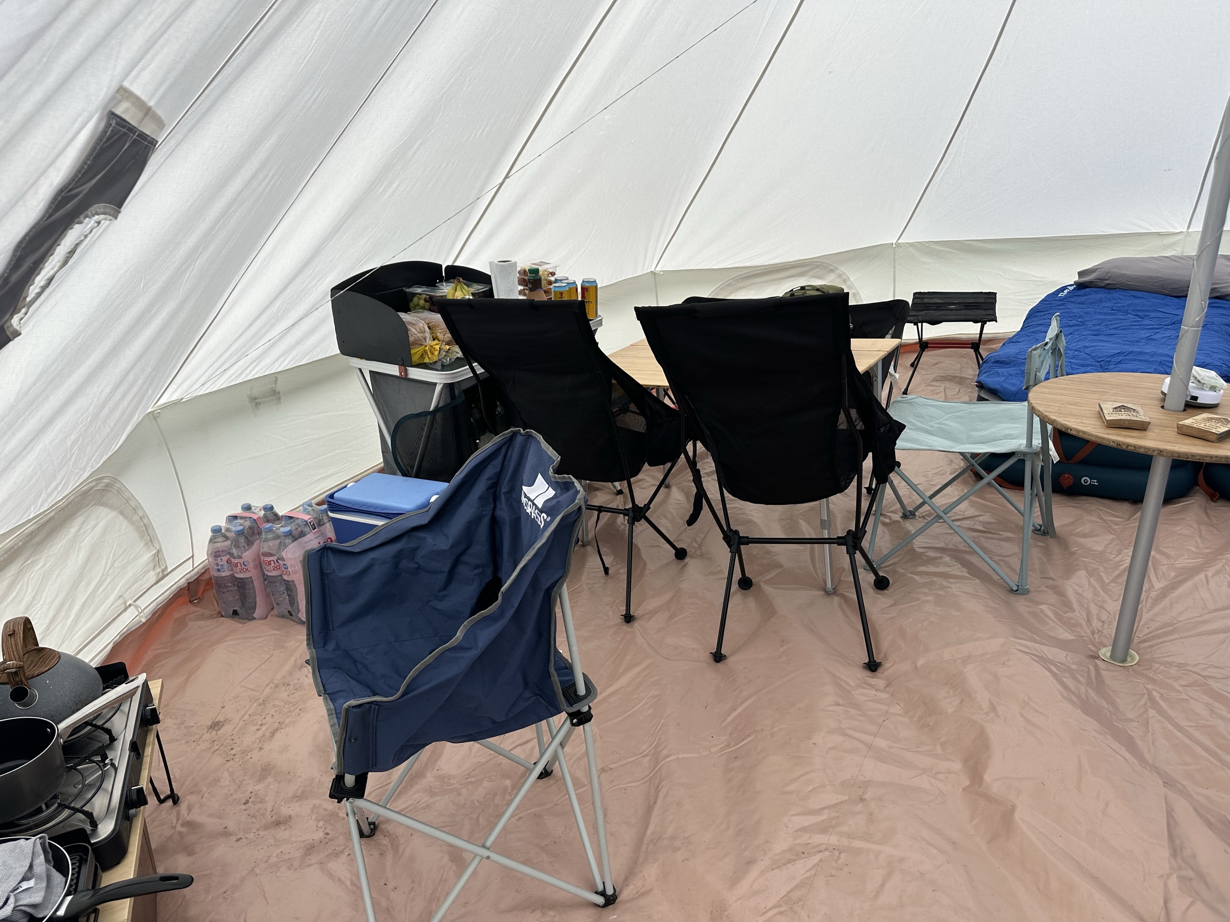 Inside the 6M: camp kitchen, table, chairs and a cooler of drinks